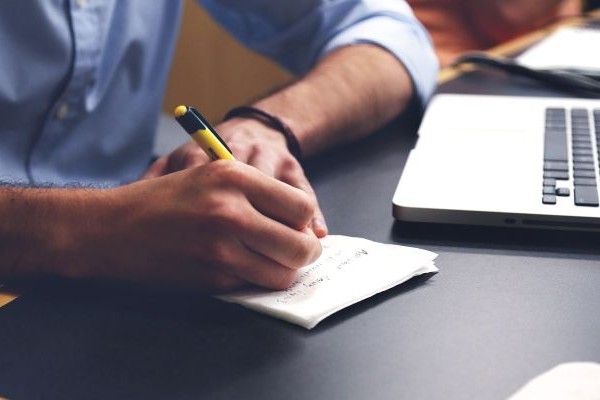 Mesa de escritório com boletos e calculadora para conferência de pagamentos